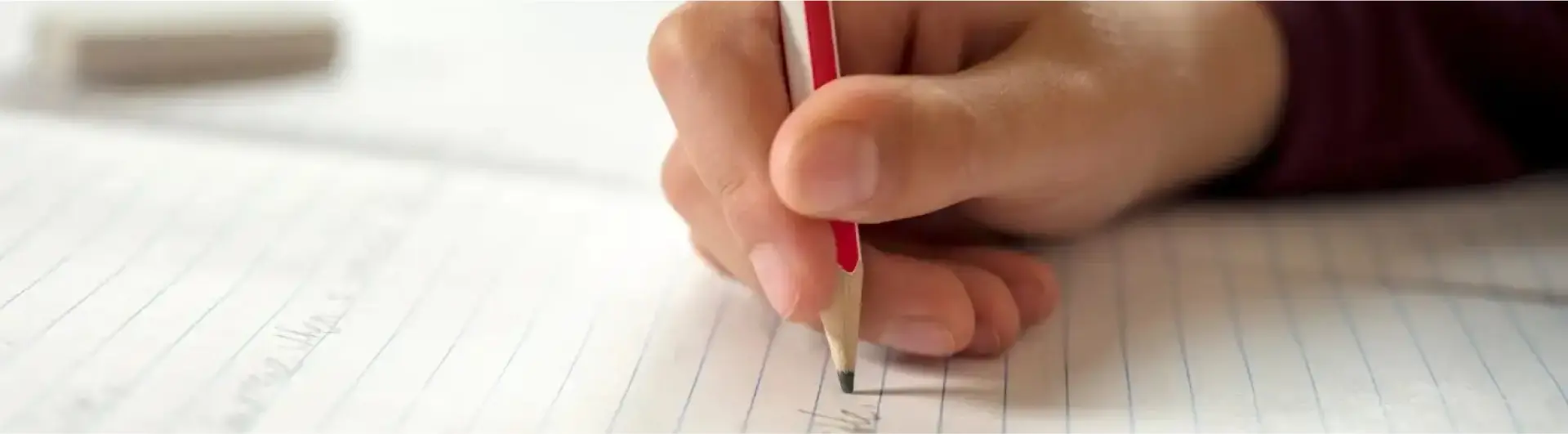 Una mano scrive con la matita su un foglio